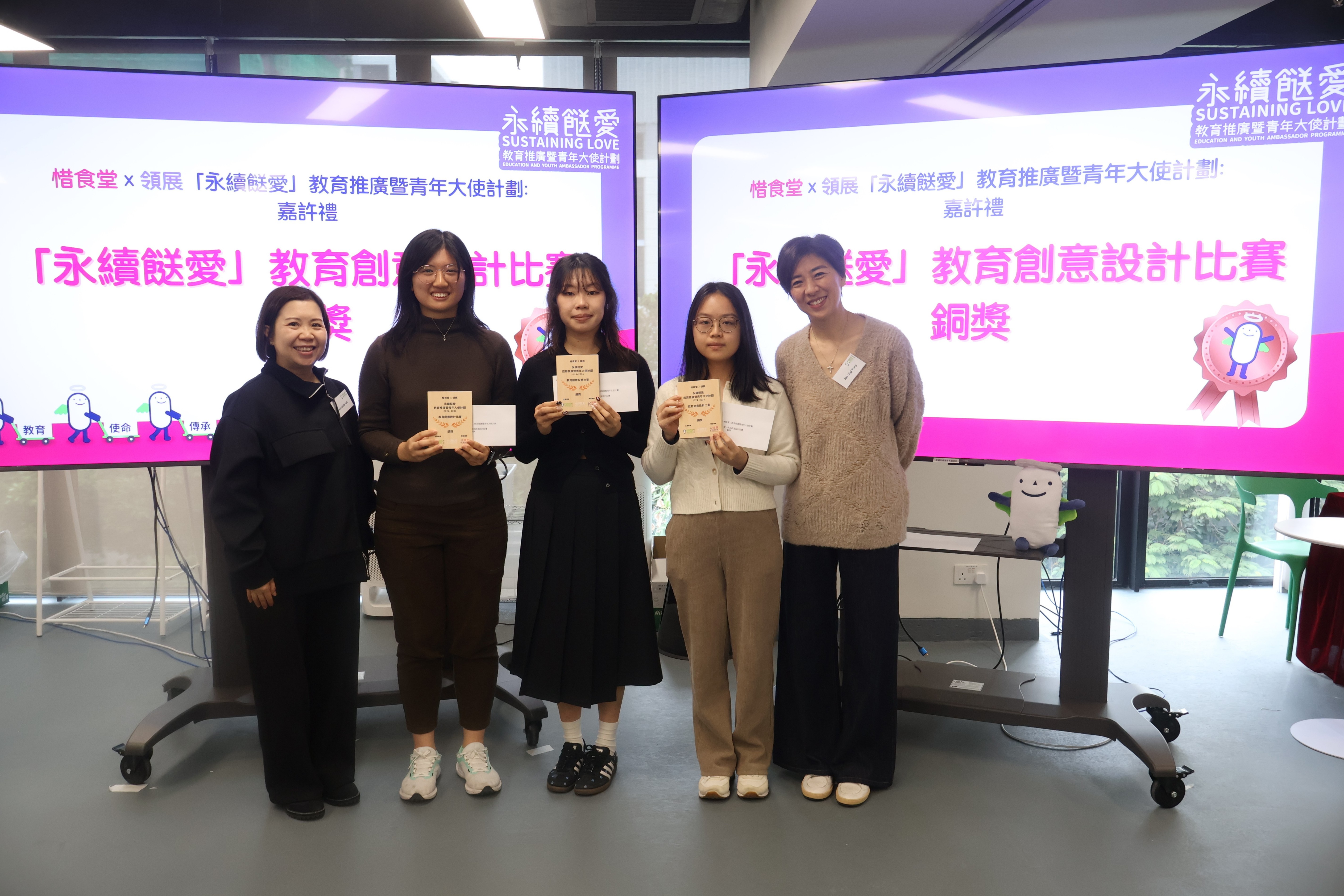 Food Angel Founder Ms Gigi Tung Oi-lai (right) presents the Bronze Award of “Sustaining Love” Educational Creative Design Competition to Ms Kitty Ng (centre).